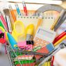 Shopping cart with colorful school stationery, back to school background